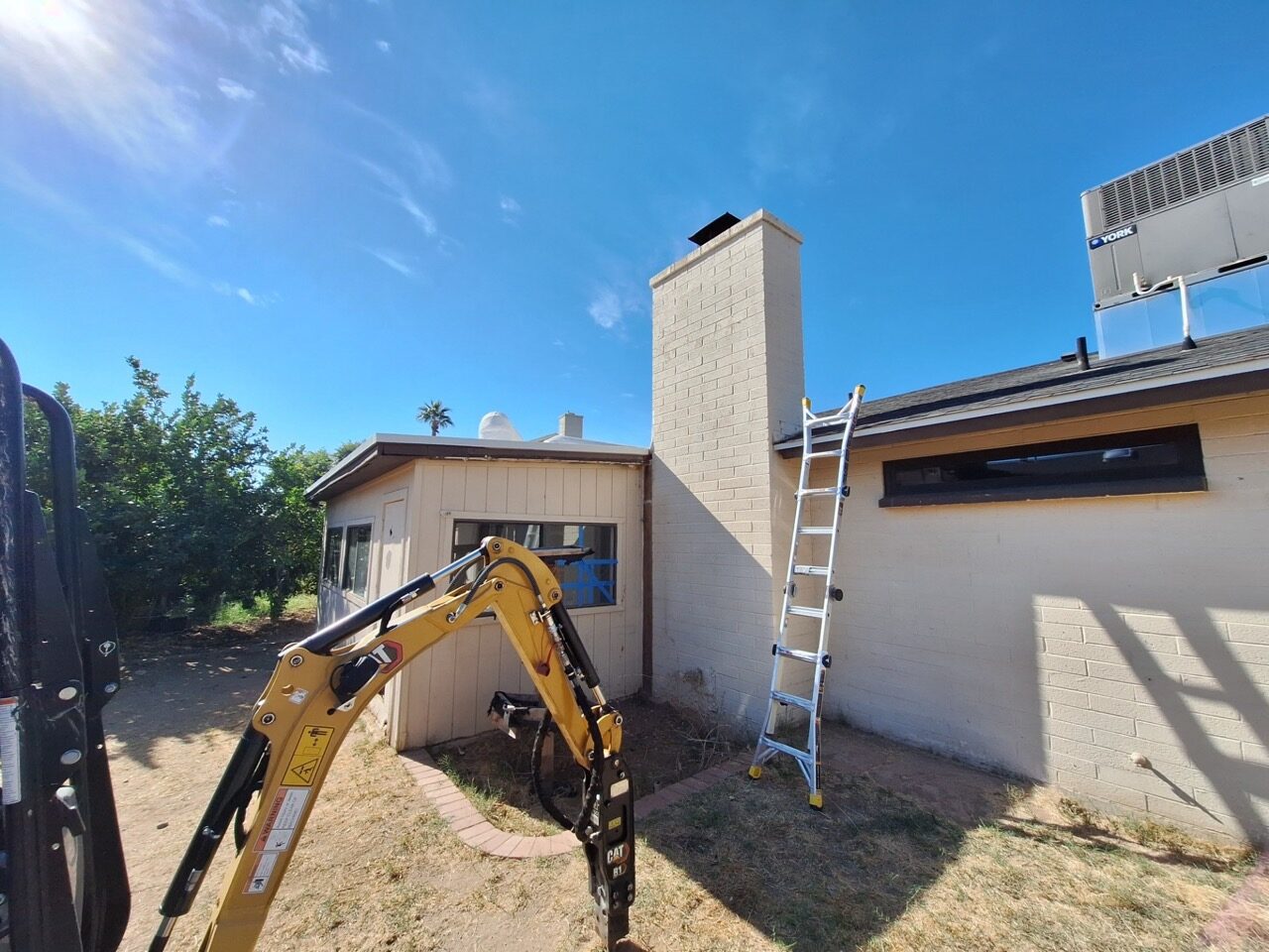 Excavator working alongside a Phoenix home during demolition