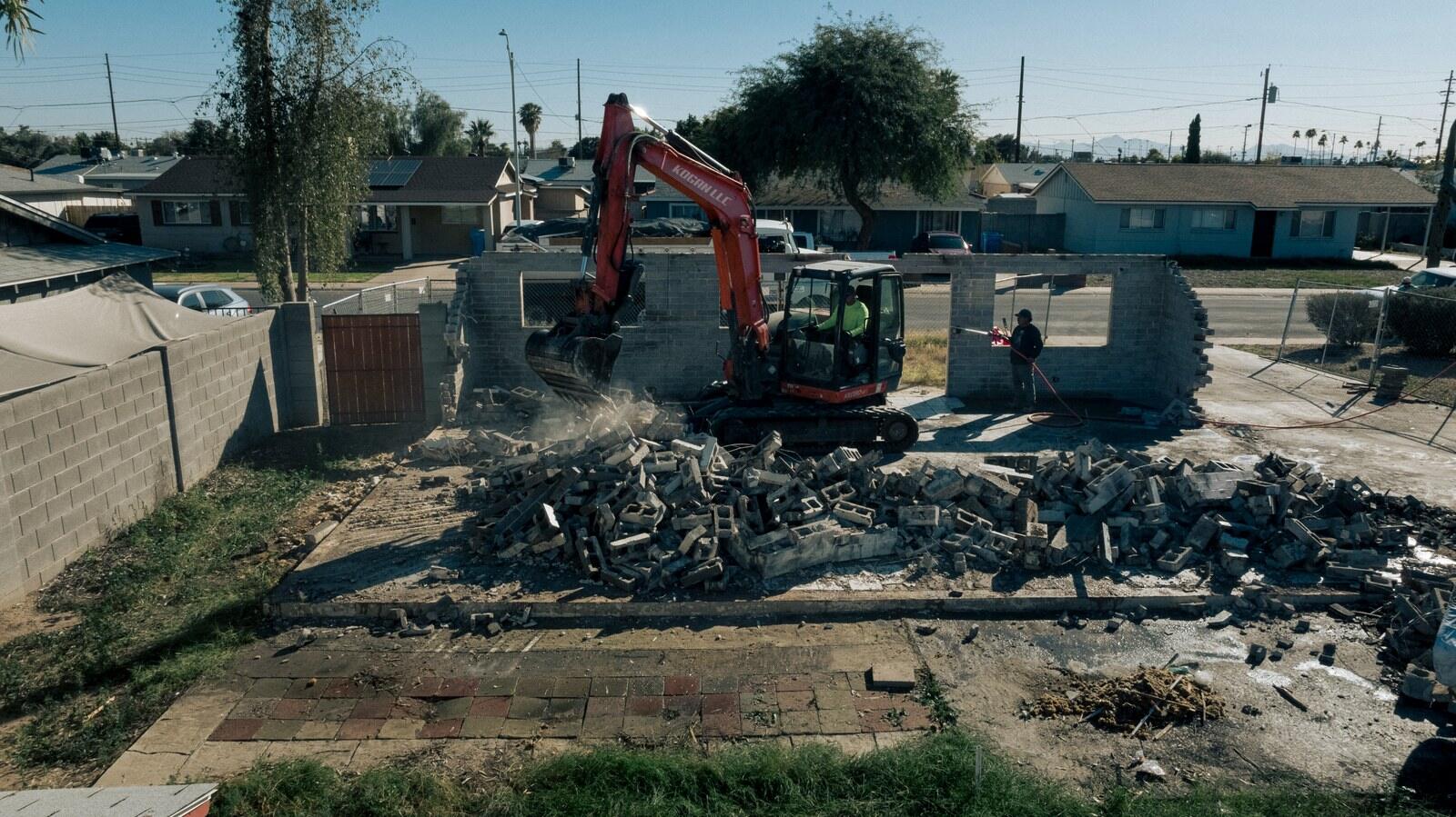Aerial view of an excavator working a cleared demolition lot in the Phoenix Valley