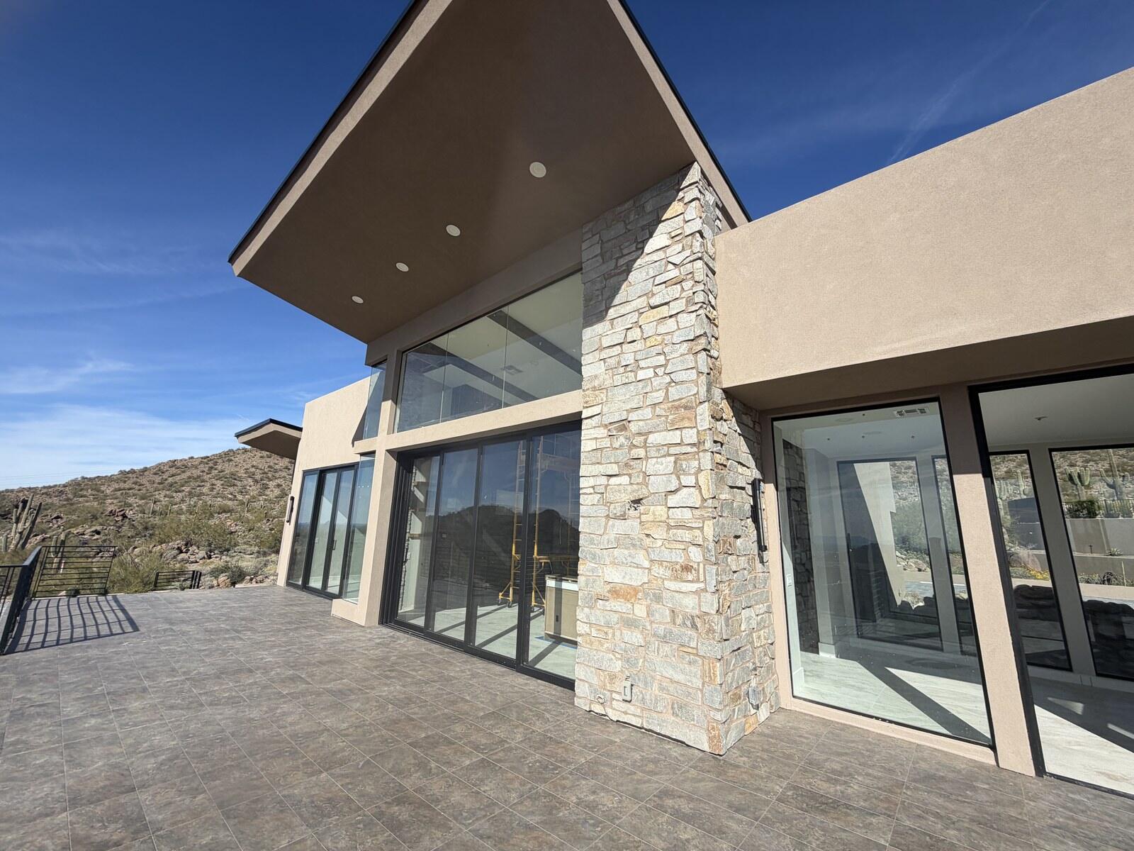 A stone-clad elevation of a custom desert home built by Kogan LLC
