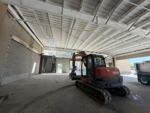 Tracked excavator working inside a warehouse shell
