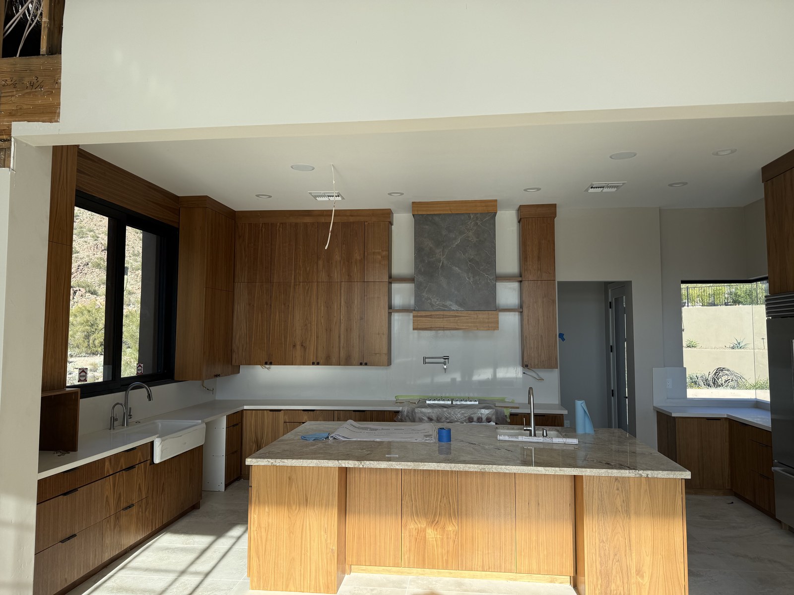 A wide view of a walnut kitchen with a stone island in a custom home built by Kogan LLC
