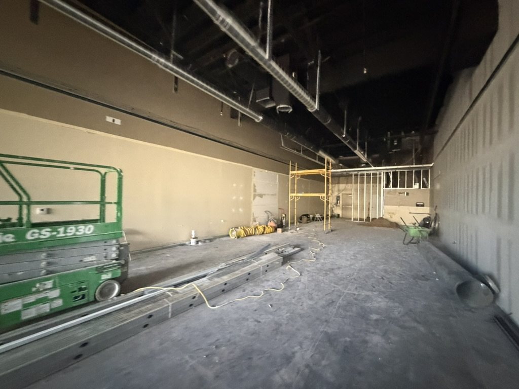 Interior build-out in progress with a scissor lift and new framing, Kogan LLC project